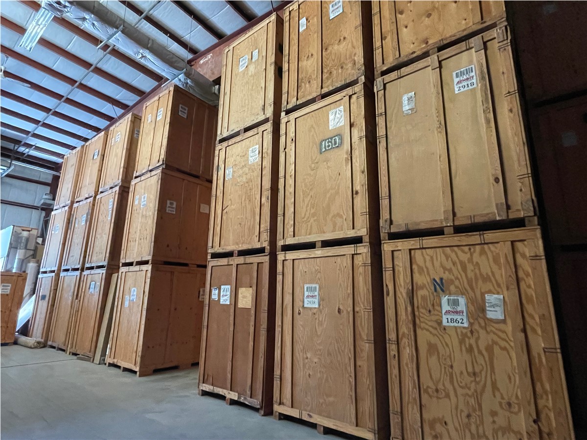The wooden storage boxes stacked in the warehouse appear to be lined arbitrarily, with each stacked to the ceiling to crea...